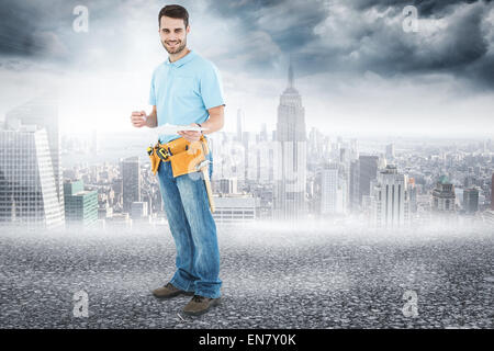 Immagine composita di sorridere lavoratore edile azienda clipbard Foto Stock