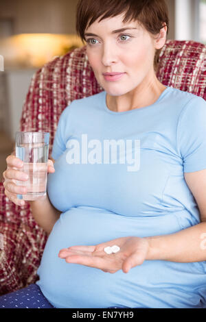 Donna incinta di prendere una compressa di vitamina Foto Stock