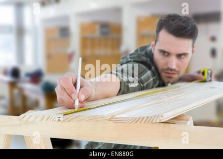 Immagine composita di lavoratore marcatura sul tavolato in legno Foto Stock