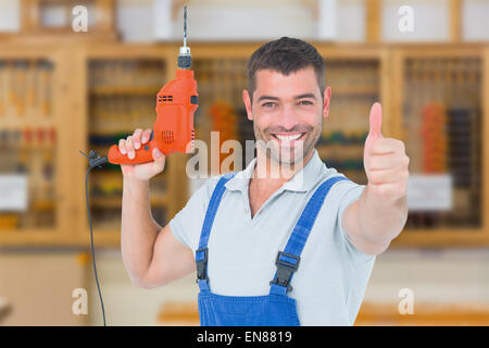 Immagine composita di sorridere aggiustatore con macchina seminatrice gesticolando pollice in alto Foto Stock
