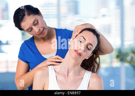 Terapista esaminando i suoi pazienti collo Foto Stock