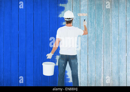 Immagine composita della vista posteriore dell'uomo mediante rullo di vernice Foto Stock