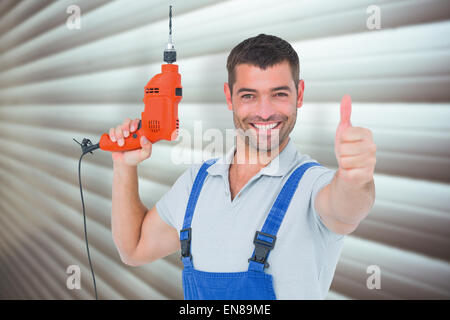Immagine composita di sorridere aggiustatore con macchina seminatrice gesticolando pollice in alto Foto Stock