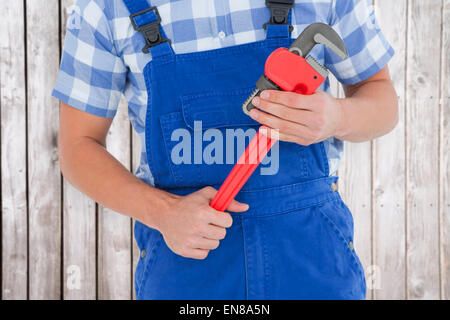 Immagine composita di aggiustatore tenendo una pinza regolabile Foto Stock