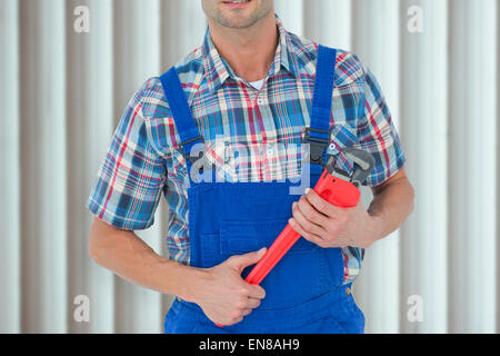 Immagine composita di immagine ritagliata di plumber holding Monkey Wrench Foto Stock