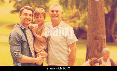 Nonno padre e figlio con la famiglia in background in posizione di parcheggio Foto Stock