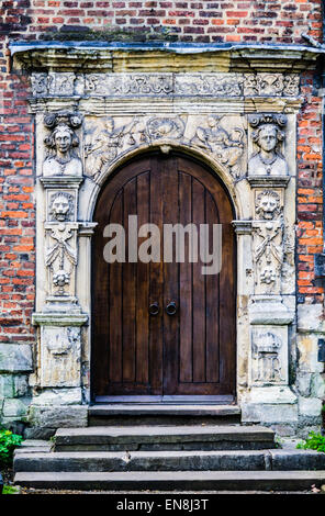 Round medievale-portale ad arco, in legno scuro doppie porte, elaborare abbellito surround, King's Manor, York, Regno Unito Foto Stock