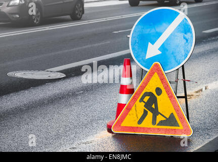 Cartelli su urban strada asfaltata. Gli uomini al lavoro Foto Stock