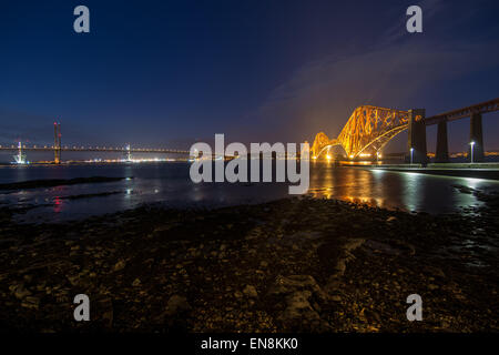 Forth Rail e ponti stradali illuminata di notte, South Queensferry, Edimburgo, Midlothian, Scotland, Regno Unito Foto Stock