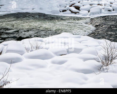 Neve e ghiaccio soffocato Arkansas River, che corre attraverso il quartiere del centro storico del piccolo paese di montagna di salida, CO Foto Stock