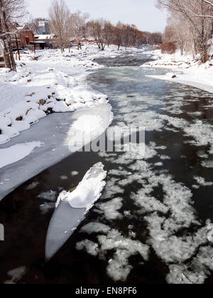 Neve e ghiaccio soffocato Arkansas River, che corre attraverso il quartiere del centro storico del piccolo paese di montagna di salida, CO Foto Stock