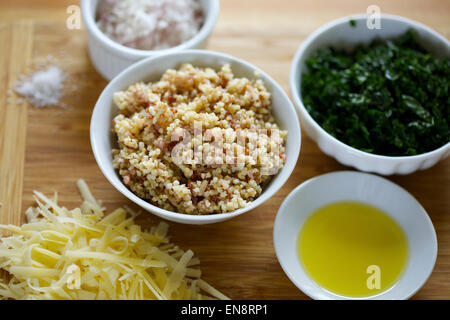 Bocce di ingredienti preparati compresi cotta la quinoa, tritato cavolo riccio, cipolla tritata, formaggio grattugiato, olio di oliva e un pizzico di sale. Foto Stock