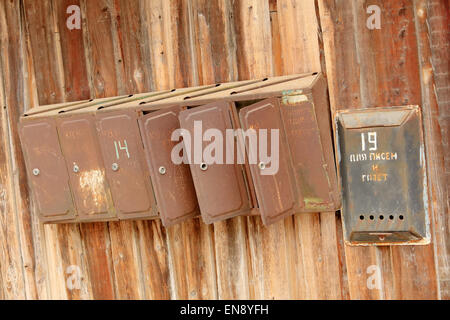 Vecchio arrugginito mailbox su una staccionata di legno. Foto Stock