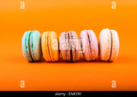 Set di macarons isolato su sfondo arancione Foto Stock