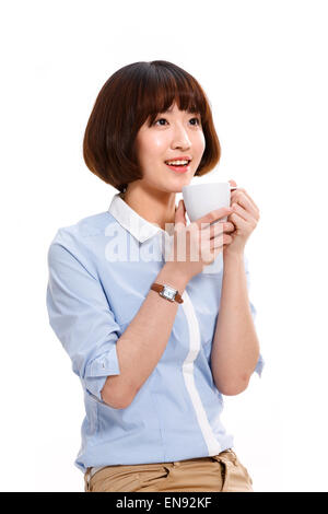 Una giovane e bella donna che mantiene una tazza Foto Stock