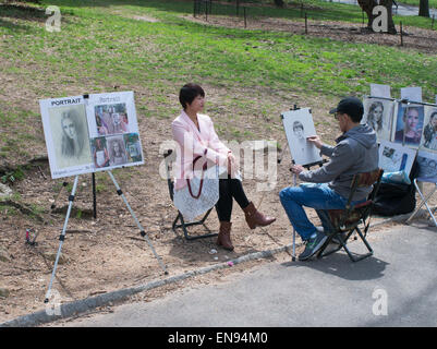 Artista di strada di disegno di un bozzetto ritratto di una giovane donna nel Central Park di New York, Stati Uniti d'America Foto Stock