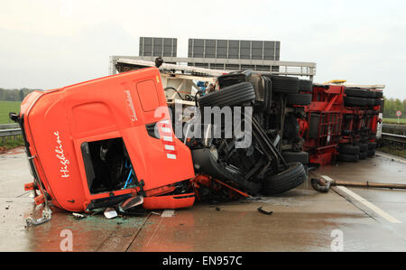 Cloppenburg, Germania. 30 apr, 2015. Ribaltato un camion della fiera si trova sulla A1 autostrada Autobahn a Cloppenburg, Germania, 30 aprile 2015. Un pianale auto transporter con tre mini furgoni era sulla spalla quando è stato eseguito da una fiera carrello. Due trasportatori sono stati scaraventati sulla strada e il carrello con fairground ride ribaltato. Un successivo carrello è stato in grado di arrivare a un arresto abbastanza rapidamente, ma la Mercedes guida dietro esso entra in collisione con il carrello. Foto: Florian KATER/dpa/Alamy Live News Foto Stock