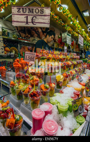 Colorato e freschi succhi di frutta in stallo al mercato La Boqueria, Barcellona, in Catalogna, Spagna Foto Stock