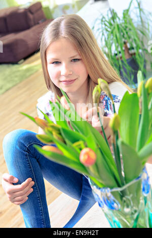 Ritratto di una ragazza con i fiori a casa Foto Stock