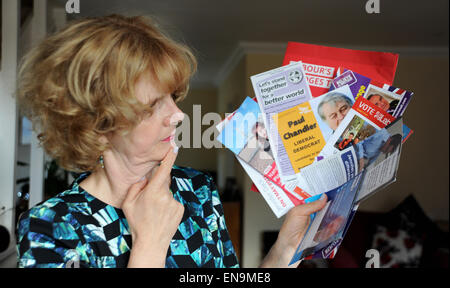 Brighton Regno Unito 30 aprile 2015 - Donna alla home azienda poster e volantini da tutti i partiti politici inviato attraverso la porta per chiedere il suo voto in questo anni elezioni generali in Gran Bretagna fotografia scattata da Simon Dack Foto Stock