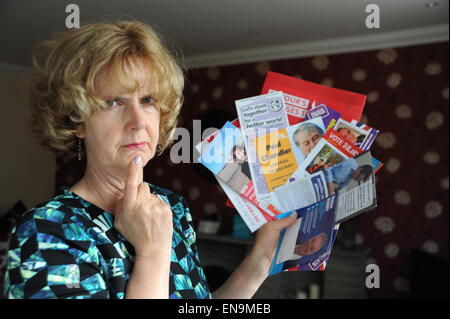 Brighton Regno Unito 30 aprile 2015 - Donna alla home azienda poster e volantini da tutti i partiti politici inviato attraverso la porta per chiedere il suo voto in questo anni elezioni generali in Gran Bretagna fotografia scattata da Simon Dack Foto Stock