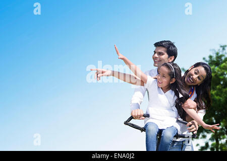 Indian genitori con la figlia del parco ciclo di equitazione Foto Stock