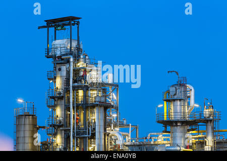 Vista di torri di distillazione di un impianto chimico e raffineria con night blue sky e illuminazione. Foto Stock