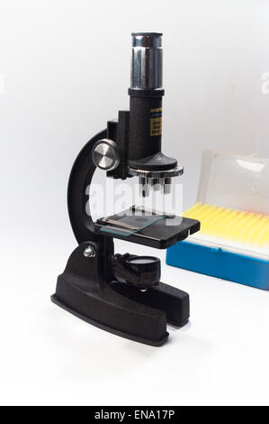 Il microscopio su uno sfondo bianco. Attrezzature scientifiche - dispositivo ottico in un laboratorio biologico. Foto Stock