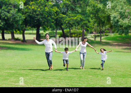 Indian genitori e bambini park in esecuzione Foto Stock