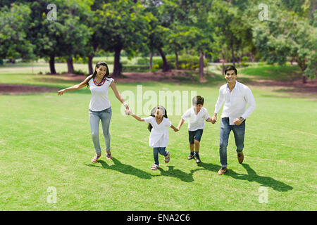 Indian genitori e bambini park in esecuzione Foto Stock