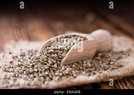 Alcune sementi di canapa (close-up shot) su sfondo di legno Foto Stock