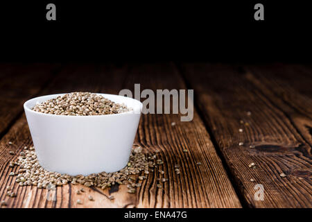 Alcune sementi di canapa (close-up shot) su sfondo di legno Foto Stock