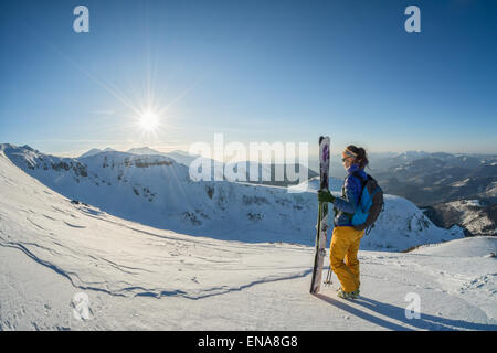Sciatore femmina guardando il tramonto dalla cima della montagna. fisheye shot Foto Stock