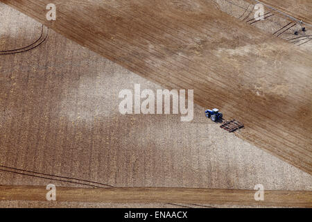 Una veduta aerea di un trattore arare un campo in preparazione per la semina. Foto Stock