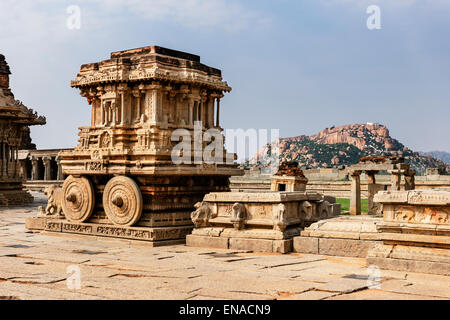 Il carro di pietra, all'interno del tempio Vittala campus, con la scimmia Hanuman tempio sulla cima della montagna nel lontano bacgro Foto Stock