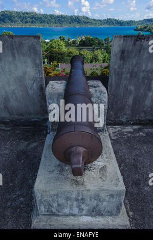 Un vecchio cannone puntato verso uno all'ingresso della baia di Banda Neira importante isola che aveva il controllo del commercio di spezie Foto Stock