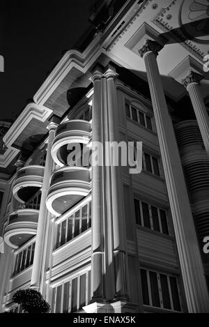 Blocco di appartamenti illuminata di notte e visto dal di sotto. La fotografia in bianco e nero Foto Stock