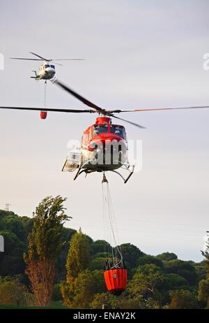 Bell 412 elicottero (registrazione N167EH) raccolta di acqua per la lotta contro gli incendi da un campo da golf lago, Cabopino Golf, Spagna. Foto Stock