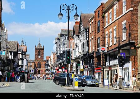 Edifici e negozi lungo Bridge Street con la chiesa di St Peters alla parte posteriore di Chester, Cheshire, Inghilterra, Regno Unito, Europa occidentale. Foto Stock