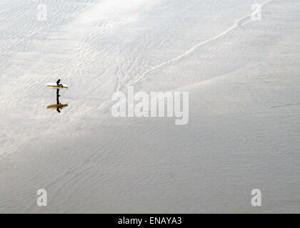 97 North Devon visualizza un lone surfer contempla il surf... su Saunton Beach domenica pomeriggio Foto Stock