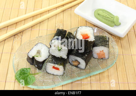 Un vaso di vetro con sushi e wasabi lascia Foto Stock