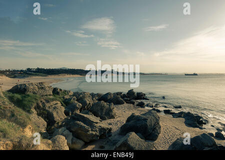 Tramonto su una spiaggia deserta con rocce in Loredo Cantabria, SPAGNA Foto Stock