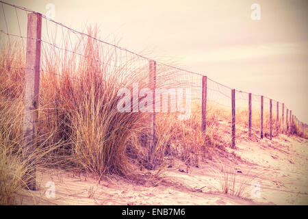 Vintage retrò foto filtrata di recinzione su una duna, natura dello sfondo. Foto Stock