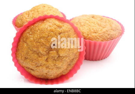 Primo piano della fresca di forno con muffin alla carota e la cannella in silicone rosso tazze. Isolato su sfondo bianco Foto Stock