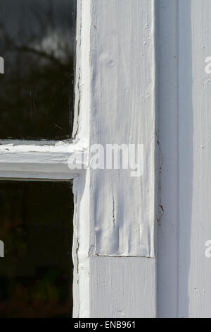 Vernice scrostata lontano da esterno smaltato singola finestra di legno la riparazione Foto Stock