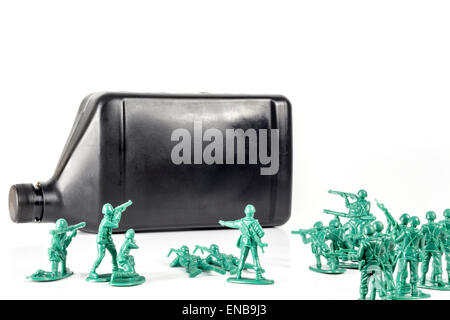 Toy army men con il quarto di gallone di olio che simboleggia una guerra per il petrolio in Medio Oriente Foto Stock