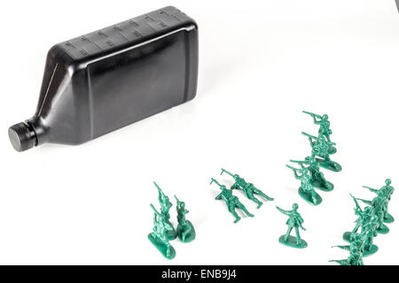 Toy army men con il quarto di gallone di olio che simboleggia una guerra per il petrolio in Medio Oriente Foto Stock