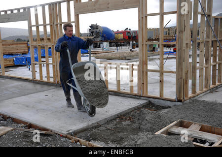 Builder versa la soletta in calcestruzzo in un edificio di grandi dimensioni Foto Stock