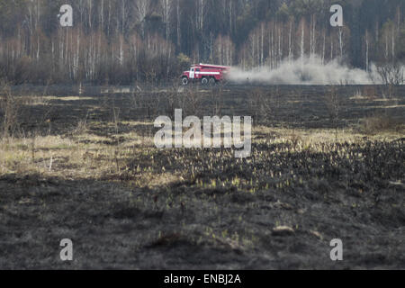 Chernobyl, in Ucraina. Il 1 maggio, 2015. Vigili del fuoco ucraino di riposo e di pompare acqua da un piccolo fiume dopo la lotta antincendio nei pressi di Lubyanka villaggio a circa 25 km dalla centrale nucleare di Cernobyl, Ucraina, 01 maggio 2015. Un incendio infuriò vicino alla centrale nucleare di Cernobyl è stato messo sotto controllo, autorità ucraine hanno detto in aprile 29. I vigili del fuoco hanno spento le fiamme a diffondere ulteriormente, l'Ucraino di situazioni di emergenza il servizio, che supervisiona il paese di vigili del fuoco, detto a Kiev. Credito: ZUMA Press, Inc./Alamy Live News Foto Stock