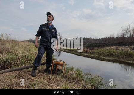 Chernobyl, in Ucraina. Il 1 maggio, 2015. Vigili del fuoco ucraino di riposo e di pompare acqua da un piccolo fiume dopo la lotta antincendio nei pressi di Lubyanka villaggio a circa 25 km dalla centrale nucleare di Cernobyl, Ucraina, 01 maggio 2015. Un incendio infuriò vicino alla centrale nucleare di Cernobyl è stato messo sotto controllo, autorità ucraine hanno detto in aprile 29. I vigili del fuoco hanno spento le fiamme a diffondere ulteriormente, l'Ucraino di situazioni di emergenza il servizio, che supervisiona il paese di vigili del fuoco, detto a Kiev. Credito: ZUMA Press, Inc./Alamy Live News Foto Stock